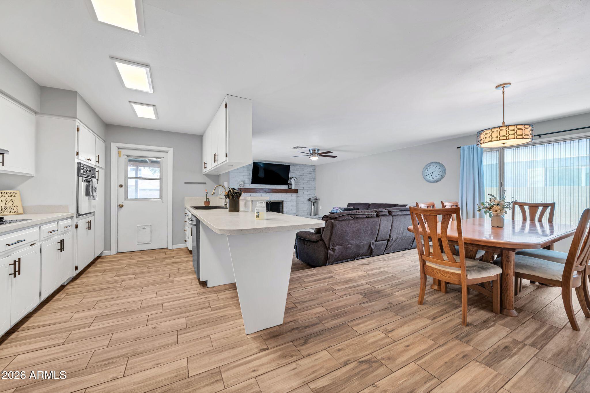 3041 West Acoma Drive Phoenix, AZ 85053 - Photo 2 of 35 a living room with furniture a dining table wooden floor and a kitchen view