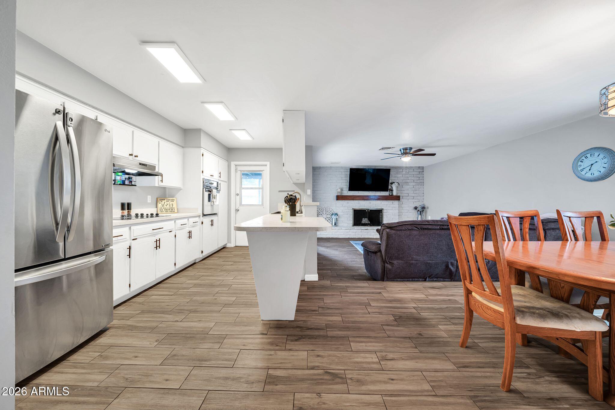 3041 West Acoma Drive Phoenix, AZ 85053 - Photo 32 of 35 a kitchen with stainless steel appliances kitchen island granite countertop a refrigerator a stove a microwave oven a dining table and chairs with wooden floor