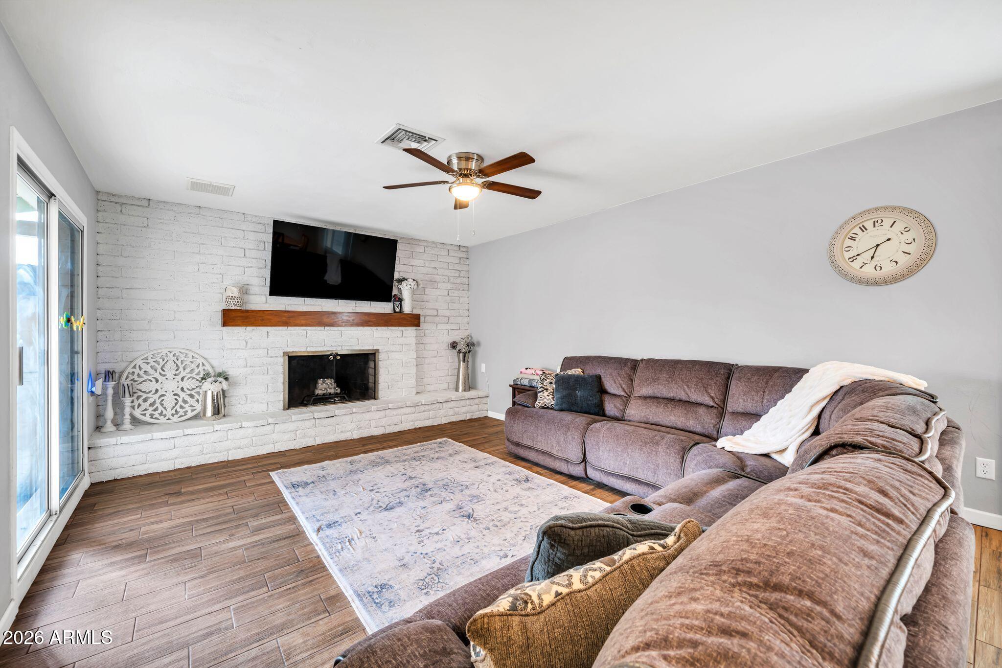 3041 West Acoma Drive Phoenix, AZ 85053 - Photo 8 of 35 a living room with furniture a fireplace and a flat screen tv
