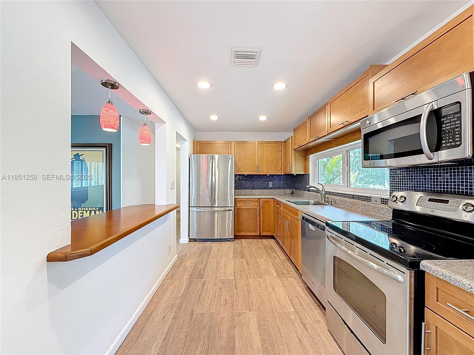 4911 Northeast 24th Avenue Lighthouse Point, FL 33064 - Photo 15 of 63 a large kitchen with stainless steel appliances granite countertop a stove and a sink
