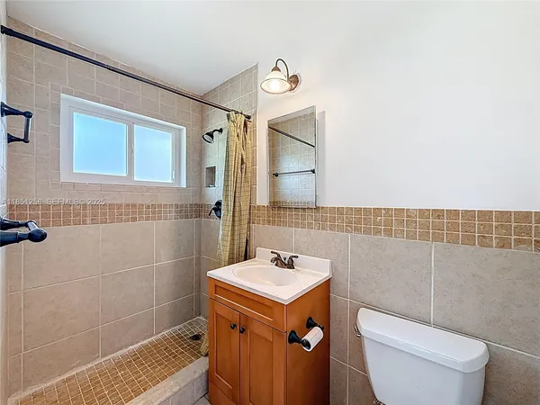 a sign board with a yard and large trees