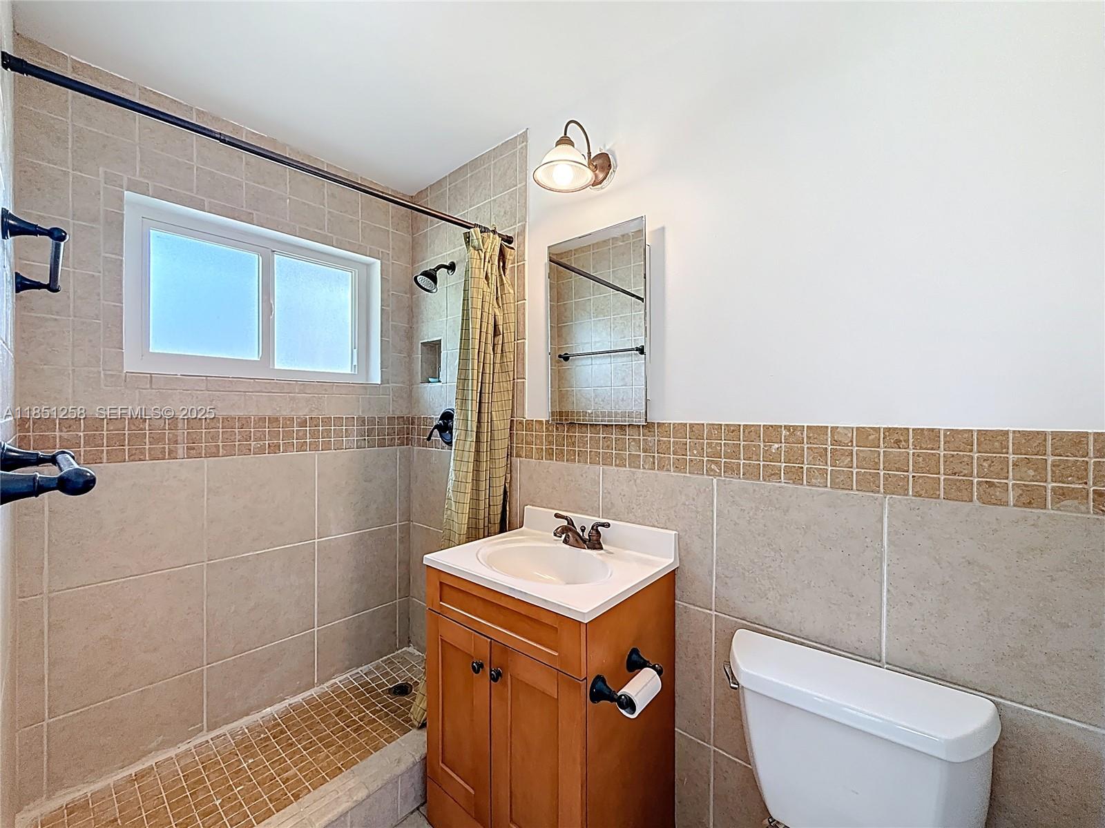 4911 Northeast 24th Avenue Lighthouse Point, FL 33064 - Photo 32 of 63 a bathroom with a sink a toilet and shower