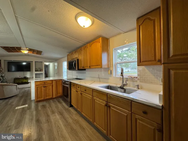 a kitchen with stainless steel appliances granite countertop a sink a stove cabinets and a microwave oven