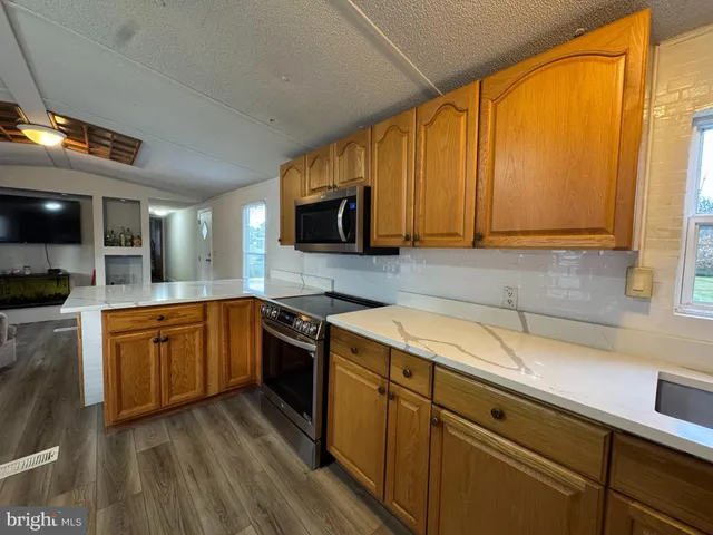 a kitchen with a sink a counter space appliances and cabinets