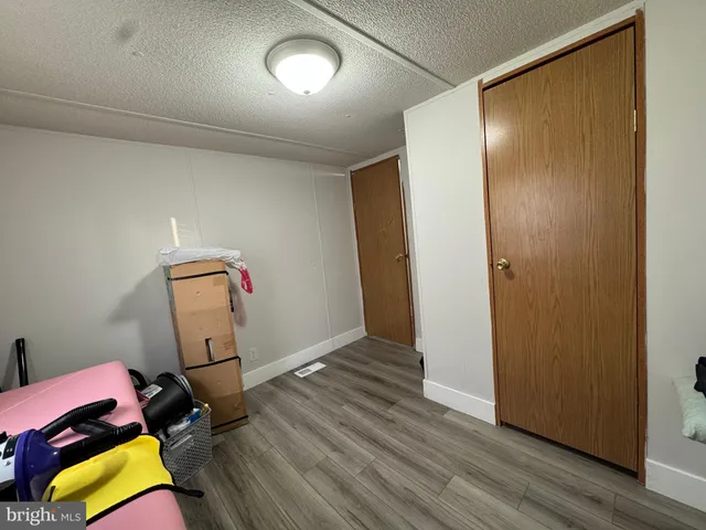 a view of a room with wooden floor and lounge chair