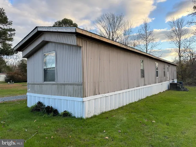 a view of backyard of house with wooden fence
