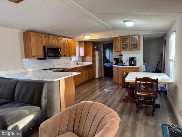 a living room with furniture a flat screen tv and kitchen view