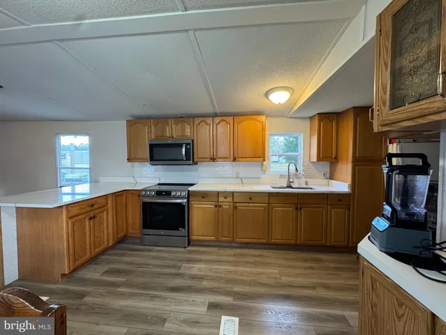 a large kitchen with stainless steel appliances granite countertop a sink and cabinets