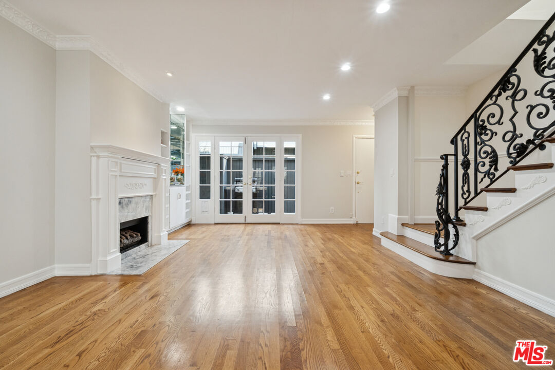 880 Hilldale Avenue, Unit 3 West Hollywood, CA 90069 - Photo 3 of 43 an empty room with wooden floor fireplace and windows