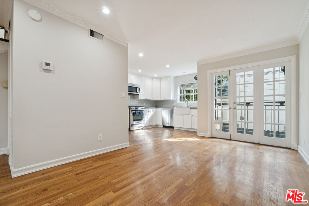 880 Hilldale Avenue, Unit 3 West Hollywood, CA 90069 - Photo 10 of 43 a view of an empty room with wooden floor and a kitchen