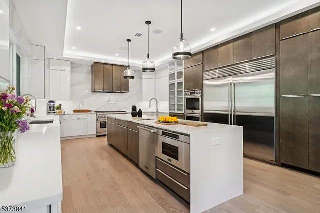 a kitchen with a stove a sink a kitchen island with a dining table and chairs