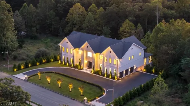 an aerial view of a house with swimming pool and trees