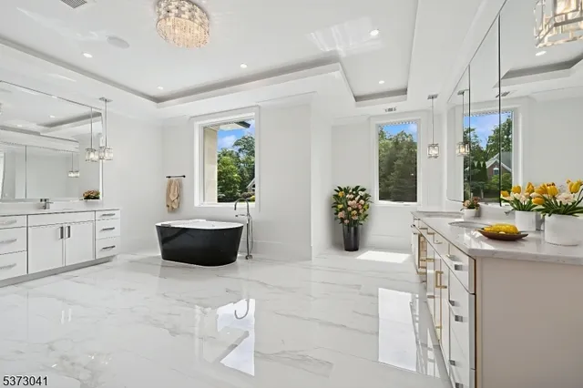 a spacious bathroom with a sink a large mirror and shower