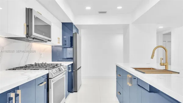 a kitchen with stainless steel appliances granite countertop a sink stove and refrigerator