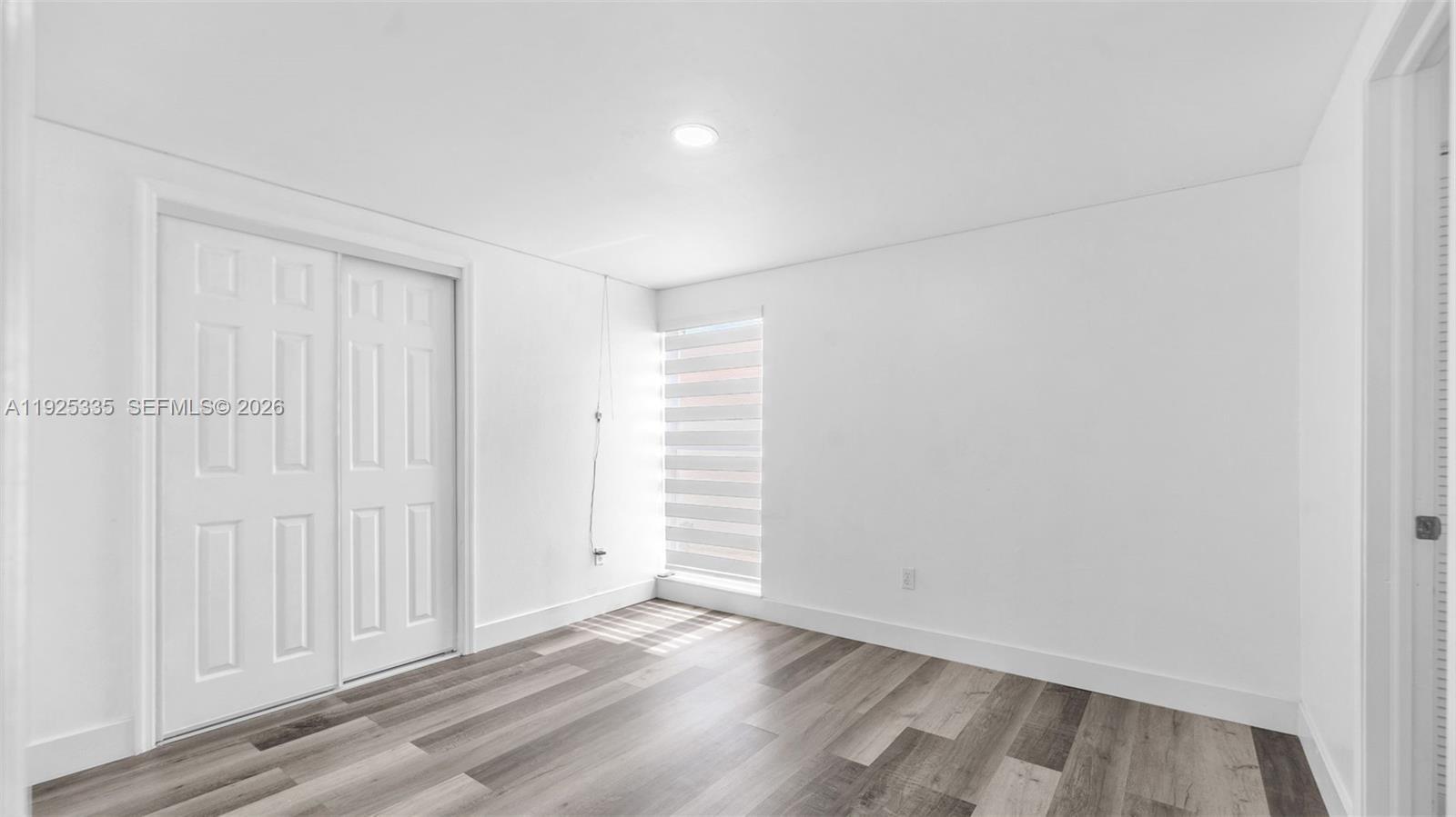 11421 Southwest 84th Street, Unit 1 Miami, FL 33173 - Photo 19 of 44 a view of an empty room and wooden floor