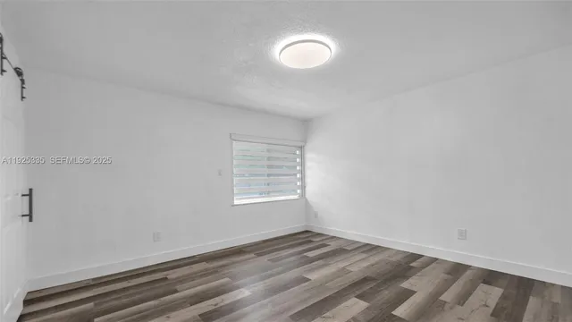 a view of a room with wooden floor