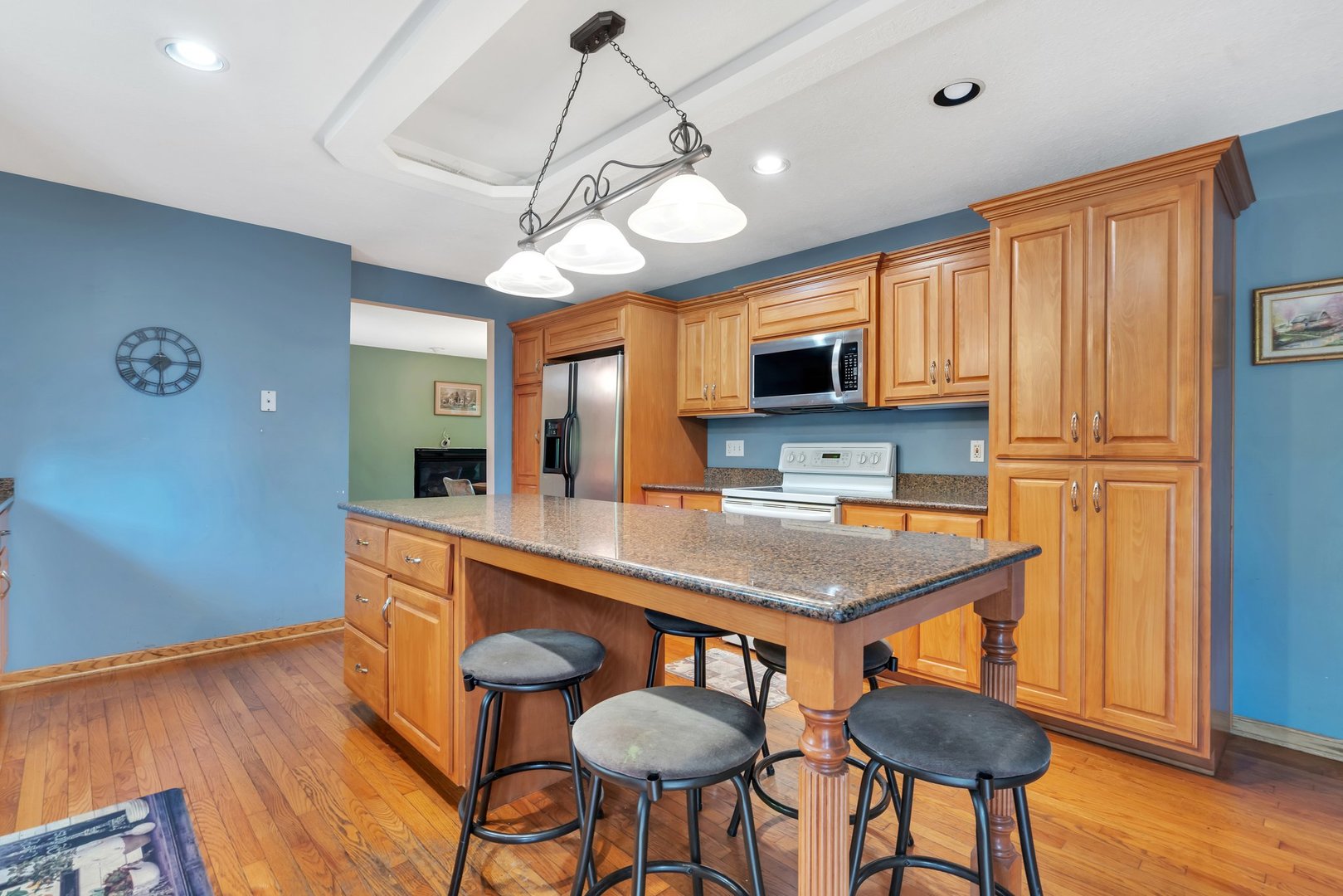 13130 McKanna Road Minooka, IL 60447 - Photo 12 of 56 a kitchen with stainless steel appliances granite countertop a stove a refrigerator a sink a dining table and chairs with wooden floor
