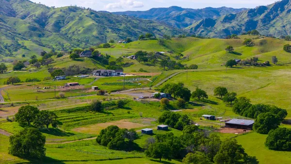 a view of a lush green hillside and houses
