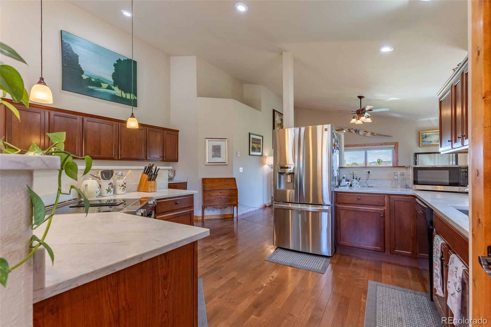 137 Starbuck Circle Salida, CO 81201 - Photo 20 of 50 a kitchen with stainless steel appliances kitchen island granite countertop a refrigerator a stove and a sink with wooden floor