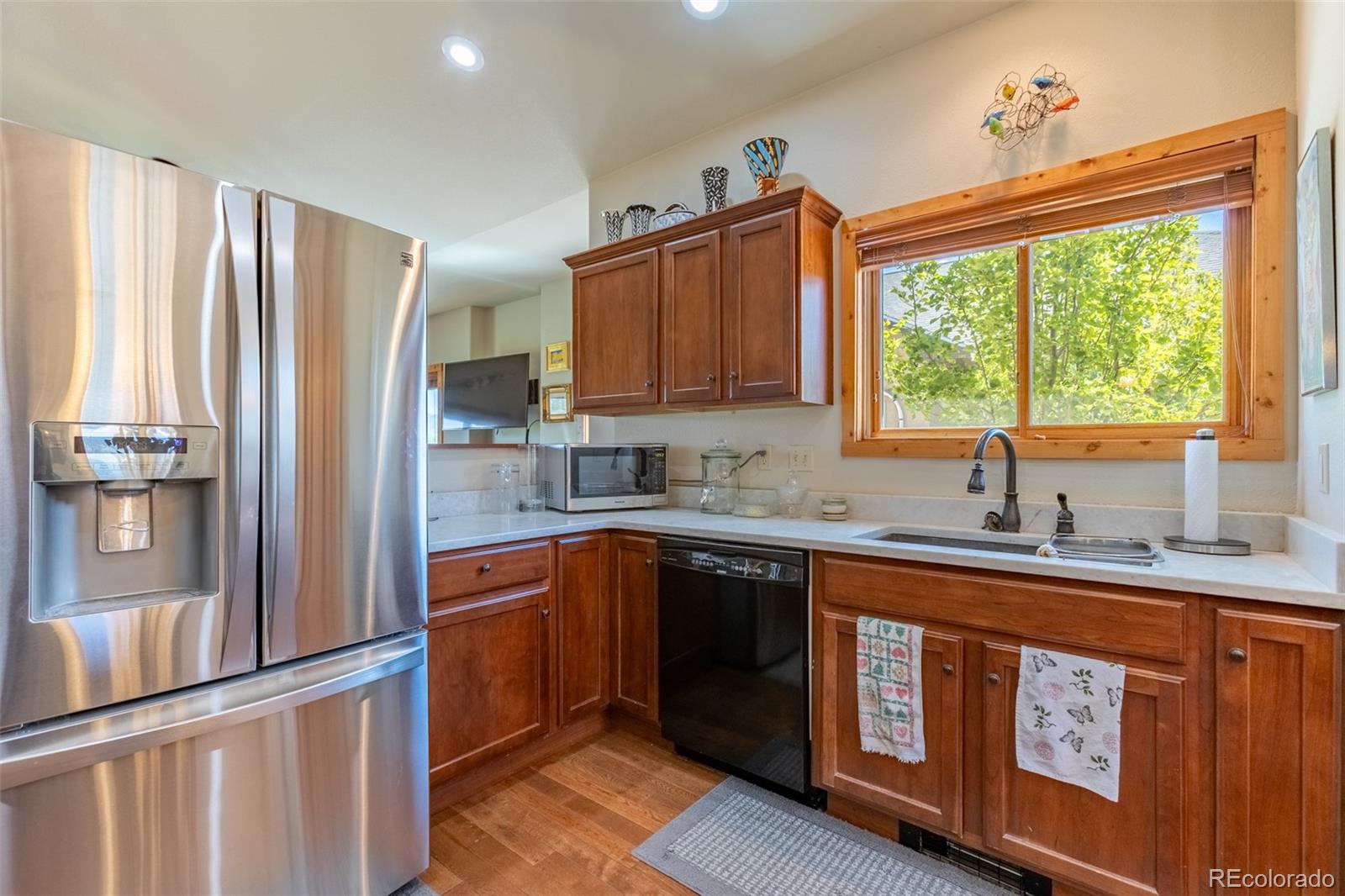 137 Starbuck Circle Salida, CO 81201 - Photo 22 of 50 a kitchen with stainless steel appliances granite countertop a refrigerator a sink dishwasher a stove and white countertops with wooden floor