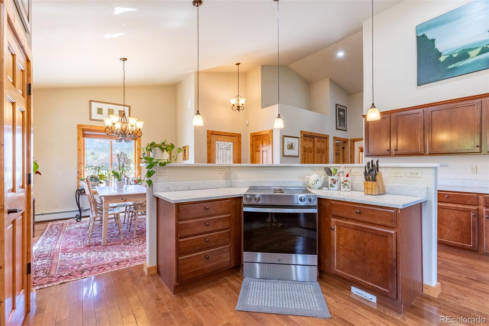 137 Starbuck Circle Salida, CO 81201 - Photo 23 of 50 a kitchen with kitchen island granite countertop a stove a sink a oven and a dining table with wooden floor