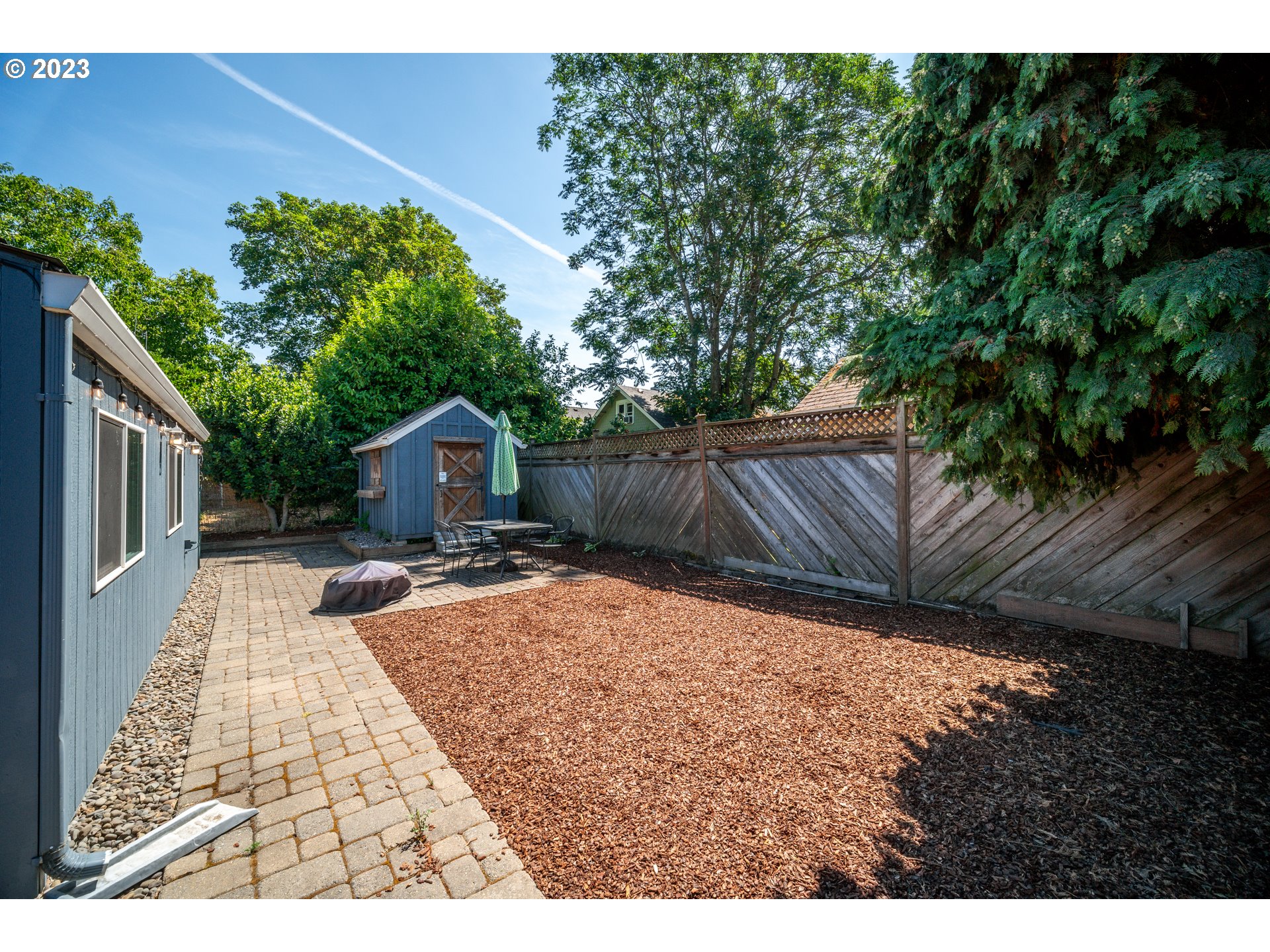 709 West Fourth Plain Boulevard Vancouver, WA 98660 - Photo 26 of 29 a backyard of a house with table and chairs plants and large tree