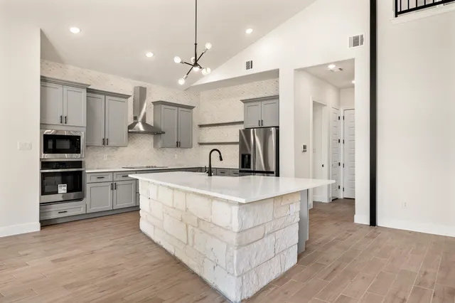 a large kitchen with stainless steel appliances kitchen island a large counter top and a sink