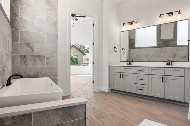 a spacious bathroom with a tub sink and mirror