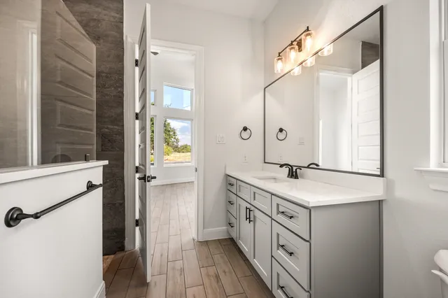 a bathroom with a double vanity sink a mirror and a shower