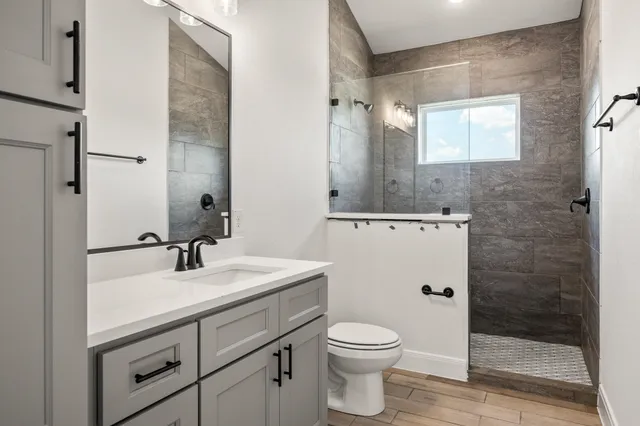 a bathroom with a sink a toilet and shower