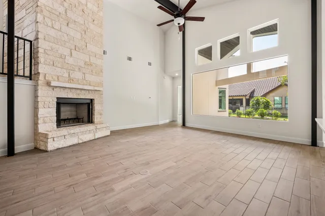 a view of an empty room with a fireplace and a window