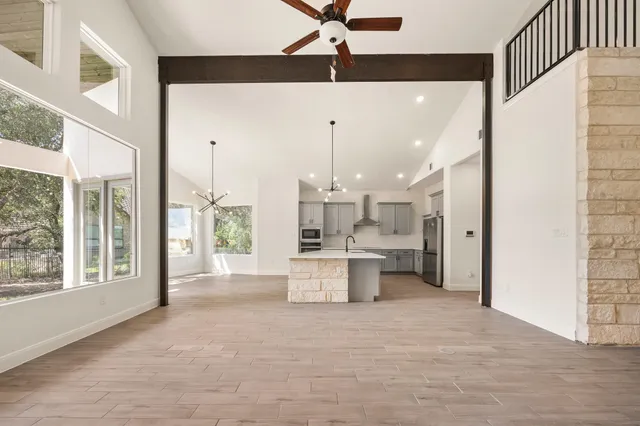 a large white kitchen with a large window appliances and cabinets
