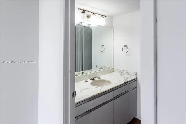 a bathroom with a granite countertop sink and a mirror