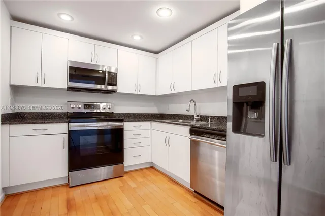 a kitchen with stainless steel appliances granite countertop a stove a sink and a refrigerator