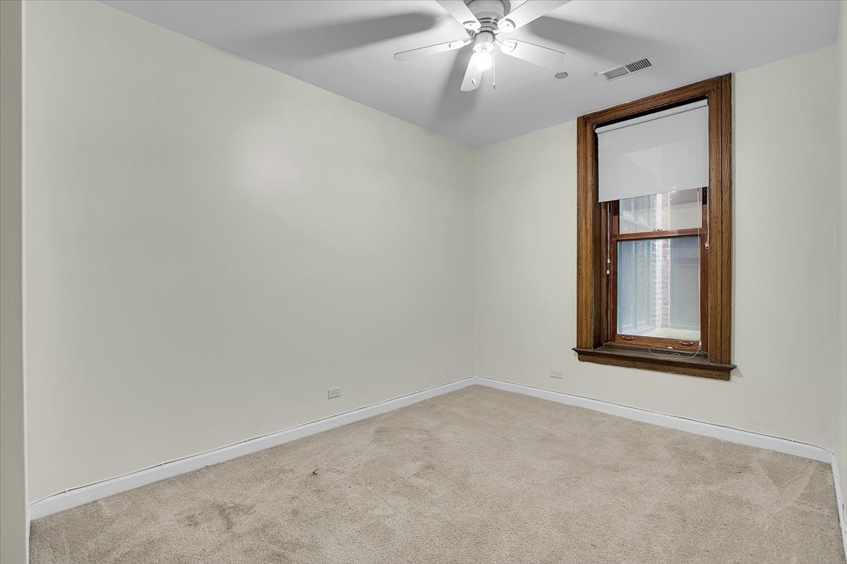550 West Surf Street, Unit 115 Chicago, IL 60657 - Photo 14 of 18 an empty room with a window and ceiling fan