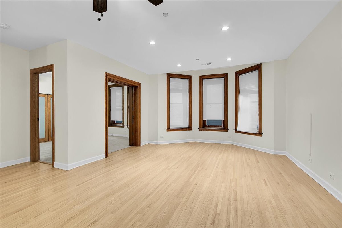 550 West Surf Street, Unit 115 Chicago, IL 60657 - Photo 5 of 18 an empty room with wooden floor and windows