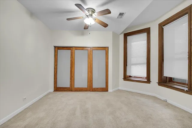 an empty room with windows and fan