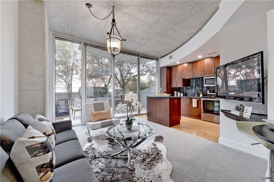 a living room with furniture kitchen and a large window