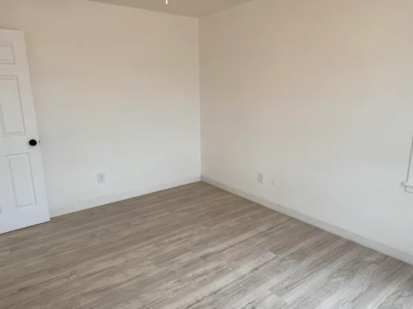 a view of an empty room with wooden floor