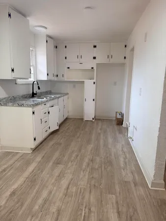 a kitchen with granite countertop a sink and a stove top oven