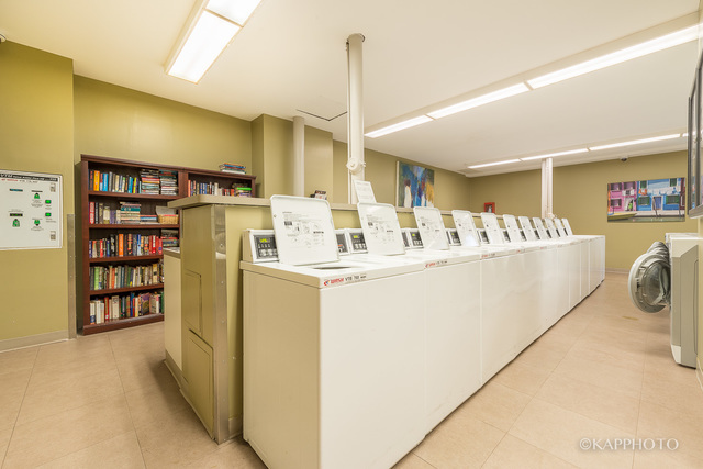 1030 North State Street, Unit 40G Chicago, IL 60610 - Photo 14 of 20 a room with a couch and a bookshelf with wooden floor