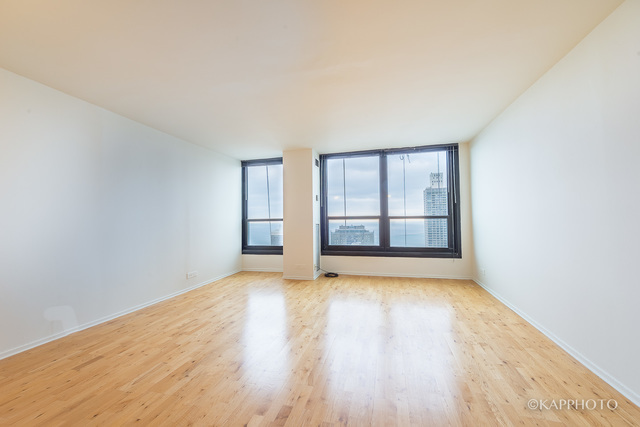 1030 North State Street, Unit 40G Chicago, IL 60610 - Photo 2 of 20 an empty room with wooden floor and windows