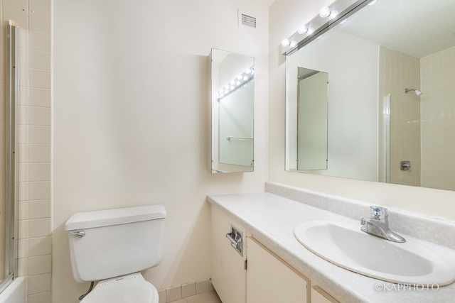 1030 North State Street, Unit 40G Chicago, IL 60610 - Photo 8 of 20 a bathroom with a toilet sink and mirror