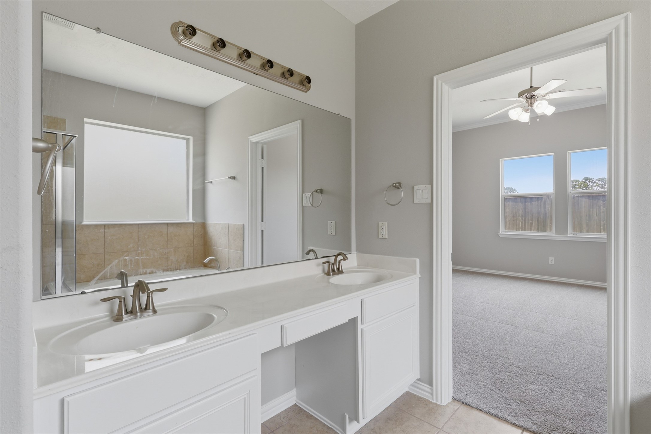 25926 Morgan Springs Spring, TX 77373 - Photo 24 of 49 Another view of the primary bathroom showcases the spacious dual-sink vanity with generous counter space, make up sitting area, while the adjoining primary suite offers a seamless and private owner's retreat. New Light Fixture coming!