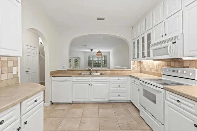 a large white kitchen with a stove a sink dishwasher and a refrigerator