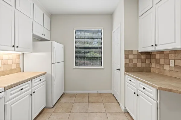a kitchen with white cabinets and white appliances