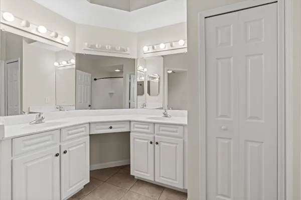 a spacious bathroom with a double vanity sink a mirror and a bathtub