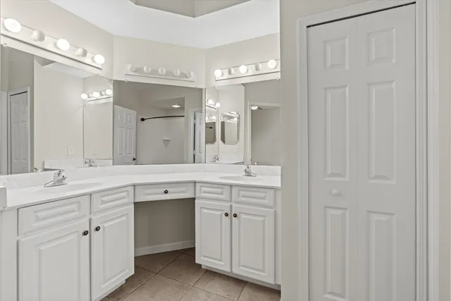 a spacious bathroom with a double vanity sink a mirror and a bathtub