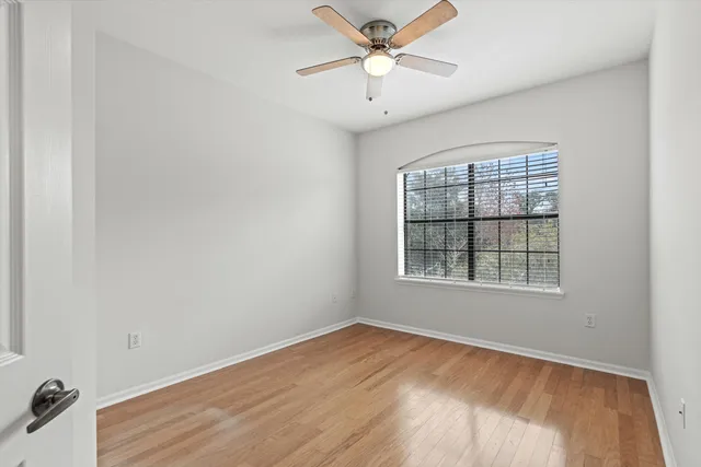 an empty room with a window and a fan