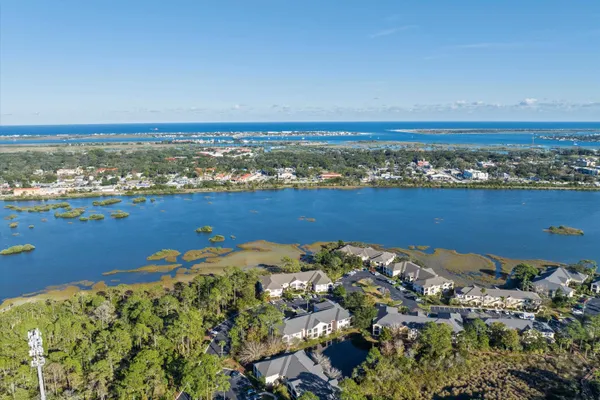 an aerial view of ocean and residential houses with outdoor space